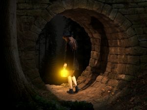 girl standing in a tunnel with a lantern