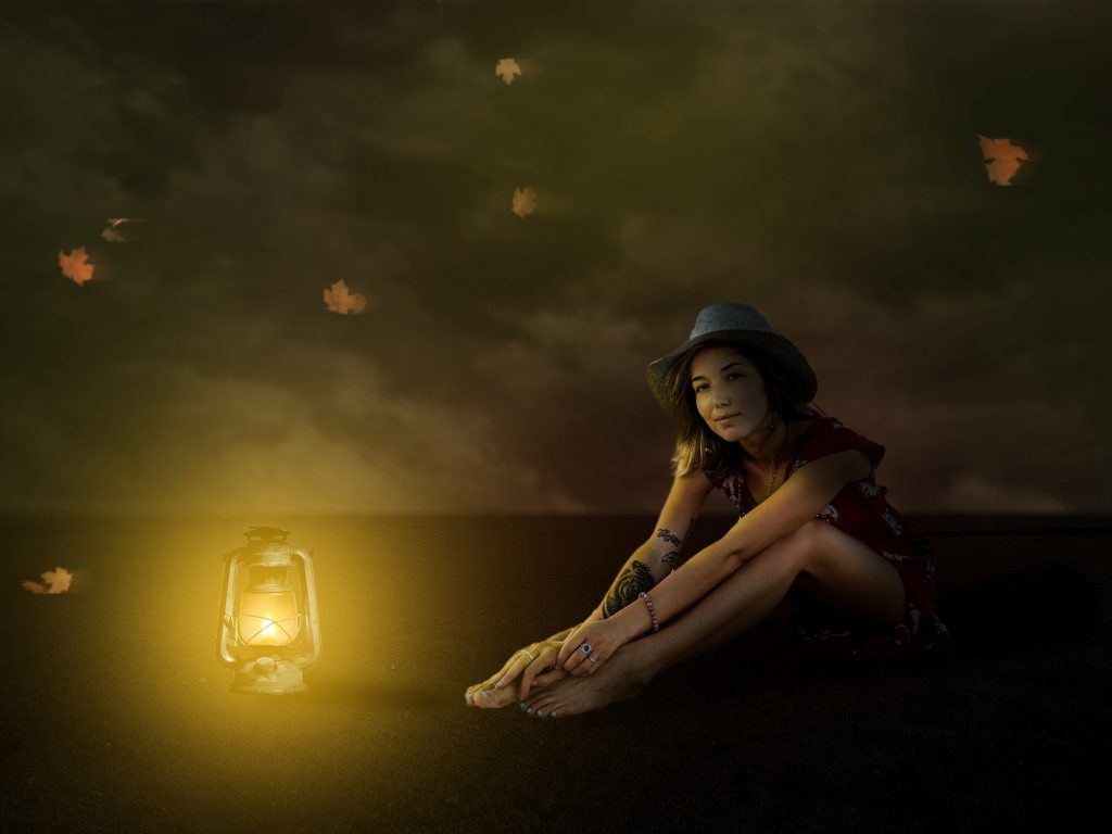 girl sitting beside a glowing lamp